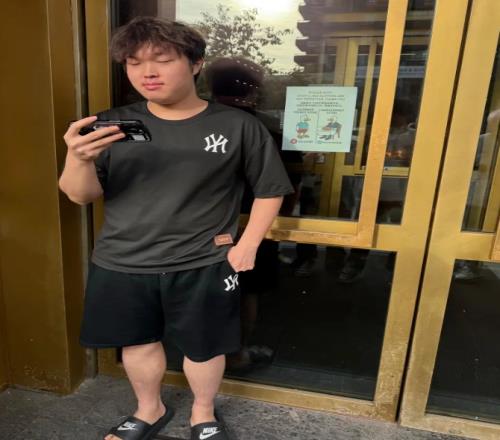 主打随意ON晒Bin因穿拖鞋短裤在餐厅门口罚站照片面带微笑疑似看T1比赛